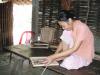 Bà Hà Thị Hồng, một người dân của làng nghề, đan mây khung gỗ tại nhà