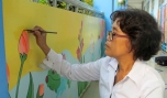 Chị Lê Huân trang trí tranh tường cho Trường Mẫu giáo xã Long Tiên.