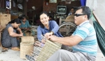 Chị Riếp hướng dẫn anh thương binh mù Nguyễn Văn Sáu thực hiện sản phẩm.