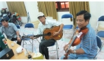 Danh cầm Đức Huệ nổi tiếng với ngón đờn Guitar tay trái và cây violon “vàng” Thanh Nhàn trong một buổi tập.
