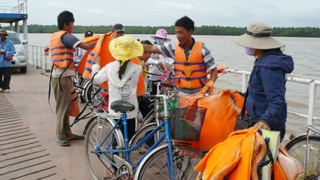 Phát áo phao trên chuyến phà qua huyện Tân Phú Đông. Ảnh: P.L