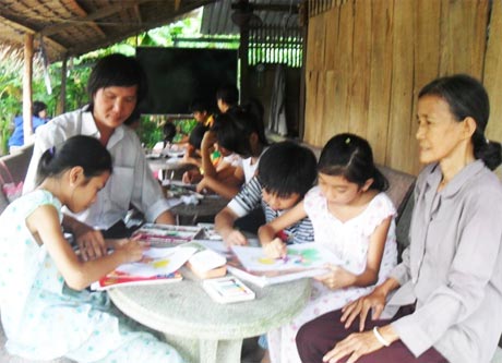 Bà Nguyễn Thị Mười và Họa sĩ Duy Bảo Việt tại lớp học vẽ miễn phí.