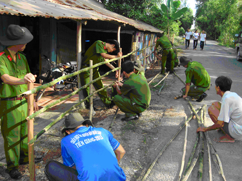 Giúp người dân làm hàng rào.