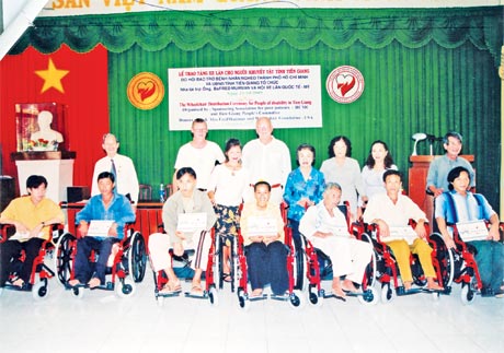 Tặng xe lăn cho người khuyết tật. Ảnh: H. Nga