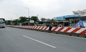 Người đi bộ "ngồi" trên dải phân cách chờ qua đường.