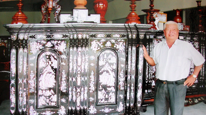 Ông Ba Đức bên tủ thờ trị giá 750 triệu đồng làm cho khách - Ảnh: Trường Giang