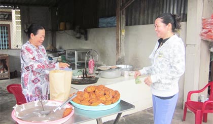Cô Mười bán bánh cho khách hàng.