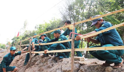 LLVT huyện Cái Bè giúp dân làm hàng rào.