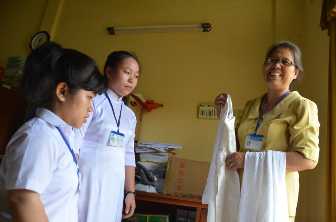 Cô Nguyễn Thị Lâu và những chiếc áo dài cũ để tặng học sinh có hoàn cảnh khó khăn - Ảnh: Thành Nhơn