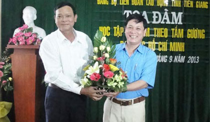 Bí thư Đảng ủy Khối các cơ quan tỉnh Nguyễn Thanh Nhàn tặng hoa chúc mừng Đảng bộ LĐLĐ tỉnh tại buổi Tọa đàm “Học tập và làm theo tấm gương đạo đức Hồ Chí Minh”.