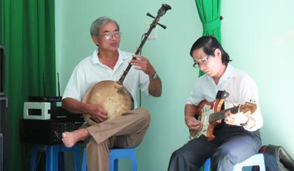 Ông Thanh (trái) khải đờn kìm tại một buổi sinh hoạt ĐCTT.