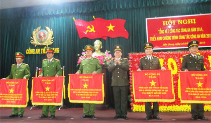 Đại diện CA TX. Gò Công (bìa trái) nhận Cờ thi đua xuất sắc của Bộ Công an tại Hội nghị tổng kết ngành Công an tỉnh năm 2014.