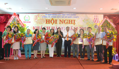 Bà Trần Kim Mai, Phó Chủ tịch Thường trực UBND tỉnh tặng Bằng khen của UBND tỉnh cho các đại lý, khách hàng có nhiều thành tích trong tiêu thụ vé số và công tác từ thiện, xã hội.