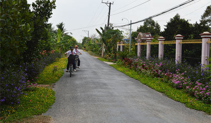 Sau 4 năm xây dựng NTM, cảnh quan, môi trường nông thôn ở xã Ngũ Hiệp, huyện Cai Lậy ngày càng khởi sắc. (Trong ảnh: Các em học sinh xã Ngũ Hiệp nô nức đến trường trên con đường rợp bóng cây xanh và hoa). Ảnh : NGỌC LAN