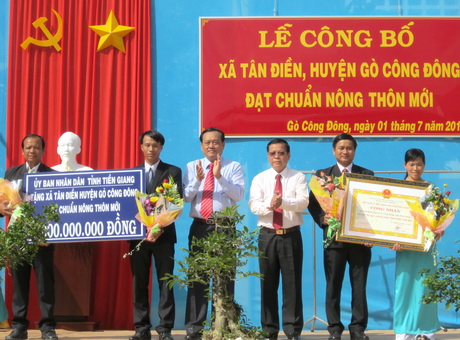 Chủ tịch UBND tỉnh Nguyễn Văn Khang và Phó Chủ tịch UBND tỉnh Lê Văn Nghĩa trao Bằng Công nhận và Công trình phúc lợi trị giá 1 tỷ đồng cho xã đạt chuẩn nông thôn mới Tân Điền.