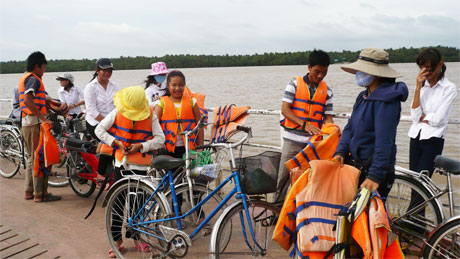 Phát áo phao cho hành khách qua phà ở bến phà Bình Ninh (xã Bình Ninh, huyện Chợ Gạo).