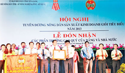 Bí thư Tỉnh ủy Trần Thế Ngọc tặng Cờ truyền thống cho Hội Nông dân tỉnh tại Hội nghị tuyên dương nông dân sản xuất kinh doanh giỏi tiêu biểu năm 2013. Ảnh: Xuân Hòa