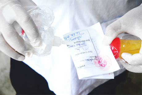 Niêm phong mẫu nước tiểu heo nghi có chất cấm.