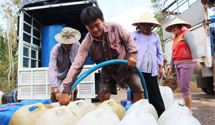 Dù đã lấy nước cho mình xong nhưng anh Tân vẫn ở lại phụ giúp bà con bơm nước vào thùng.