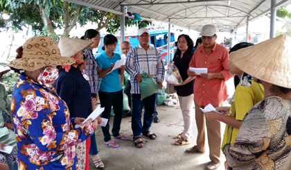 Anh Đỗ Hồng Trí (thứ 5 từ phải sang) trao quà cho các hộ nghèo, hộ khó khăn phường Tân Long, giúp bà con vui xuân, đón tết.