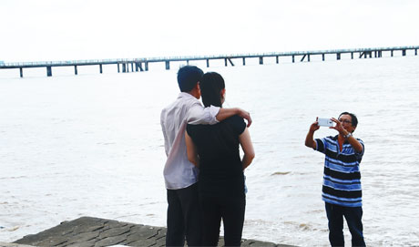 Du khách chụp ảnh trên biển.