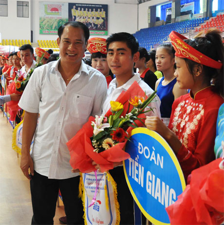 TS. Vũ Đức Thịnh (bìa trái) tặng hoa cho đoàn VĐV Tiền Giang tham gia giải.