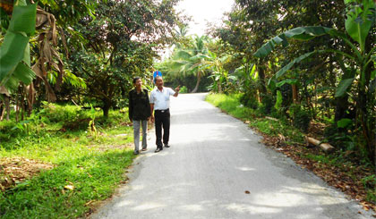 Cựu chiến binh Nguyễn Văn Triệu (trái) bên tuyến đường Bờ Mới được mở rộng.