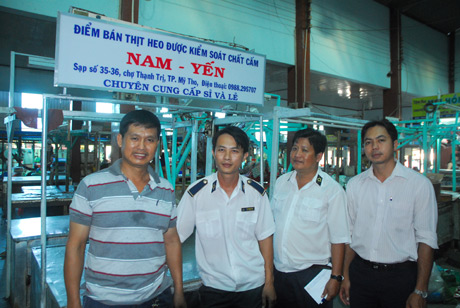 Ông Trần Hoàng Nam (bên trái) cùng ngành Thú y trong ngày khai trương sạp thịt heo “sạch”.