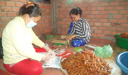 Các công nhân của cơ sở sản xuất mứt me Thanh Tuyền đang gói mứt me.