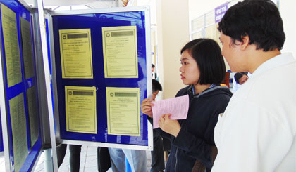 Người lao động tìm hiểu thông tin tuyển dụng của các DN tại một phiên giao dịch việc làm.