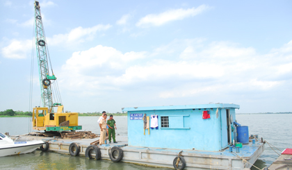 Các thành viên trong Đoàn kiểm tra hội ý để kéo chiếc sà lan vi phạm về TP. Mỹ Tho.